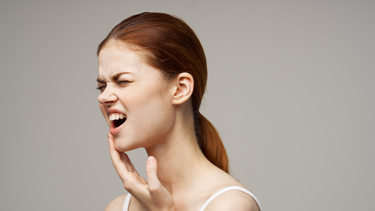 Close-up of red-haired woman with jaw pain