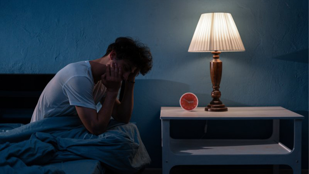 man sitting up after having a bad dream at night
